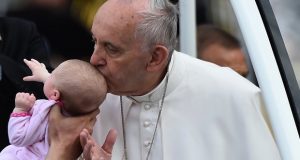 Папата целува по главата бебе
